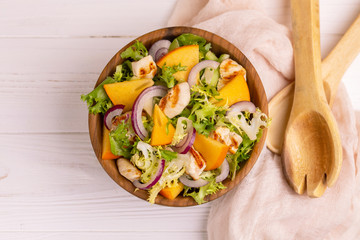 Tasty salad with frisee, persimmon, grilled chicken fillet and sesame