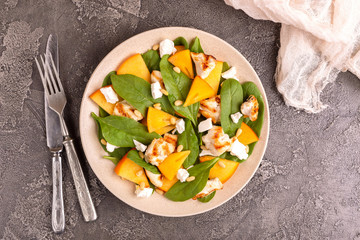Exotic salad with spinach, persimmon, grilled chicken fillet, feta