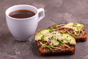 Tasty rye toasts with avocado, radish sprouts and sesame