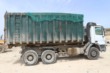 Hook lift truck for waste transport returns back to the waste transfer station after having unloaded in a sanitary landfill