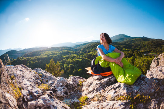 A Woman Is Sitting In A Sleeping Bag.