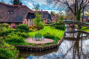 Dutch village with colorful ornamental garden and water canal, Giethoorn - obrazy, fototapety, plakaty