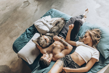 Beautiful loving couple in bed together with the dog