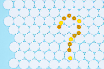 Symbol of a question mark. Conceptual for pharmaceutical.Question mark from yelloy tablets on a blue background. The medical concept.