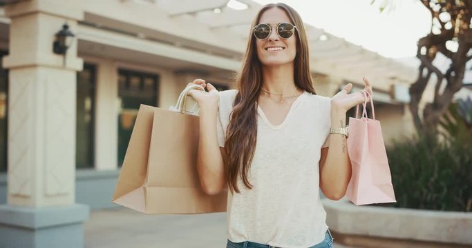 Beautiful young brunette shopping, smiling walking with shopping bags