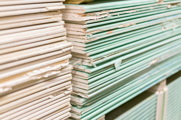 Gypsum plasterboard in the pack. The stack of gypsum board preparing for construction. Pallet with plasterboard in the building store. Construction Materials. Drywall warehouse.