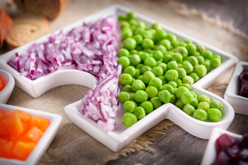 Salad for a healthy lifestyle. Raw vegetables onions and peas, sliced ​​lying on a plate. Close-up.