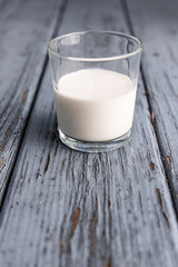 A half full glass of pin on a blue wooden floor