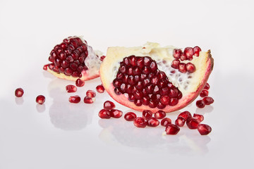 Close-up of pomegranate seeds texture on a white background, top view.  Ripe red garnet fruit Close-up of pomegranate seeds texture on a white background, top view.  Ripe red garnet fruit 