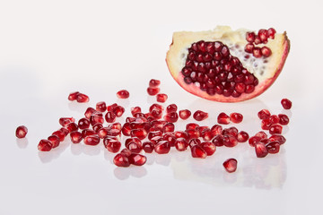 Close-up of pomegranate seeds texture on a white background, top view.  Ripe red garnet fruit Close-up of pomegranate seeds texture on a white background, top view.  Ripe red garnet fruit 