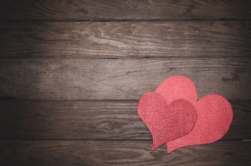 Heart made of felt on a wooden table. Frame to the day of Saint Valentine.