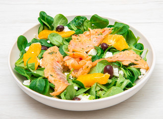 fresh salad with sliced of marinated  salmon and orange fruit