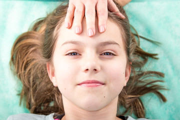 Uśmiechnięta dziewczynka podczas terapii czaszkowo-krzyżowej