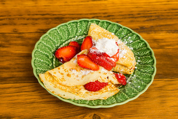 Strawberry Crepes on Green Plate in rustic setting