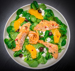 fresh salad with sliced of marinated  salmon and orange fruit