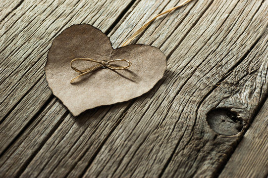 Brown paper Heart  on wooden backdrop. Happy valentines day. St. Valentine background. Holidays greeting card copy space