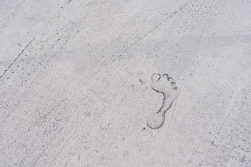 Background texture of a trace of feet and tires on the asphalt. Close-up. Texture design of car tires and a footprint of a person. Footprints of a man on black asphalt and a car.