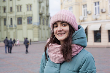 portrait of young cheerful tourist woman in the city. Beautiful architecture on background