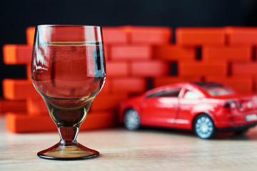  Drunk driving car crash accident. Don't drive after drink concept. Shot glass and a broken car