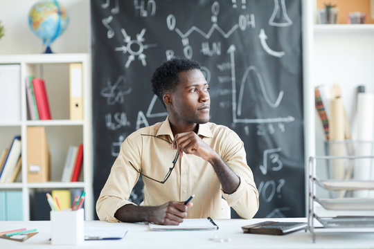 Young Secondary School Teacher Sitting By Desk And Getting Inspired While Organizing Next Lessons