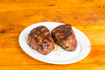 Prime Tenderloin Steaks Grilled to perfection and resting on rustic cutting board before serving