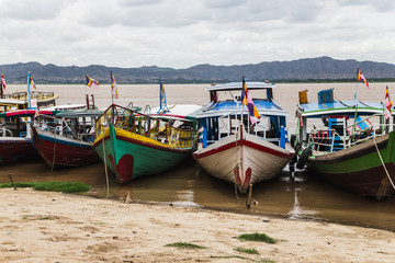 Fototapeta na wymiar Colorful boats docked on shore in Bagan, Myanmar