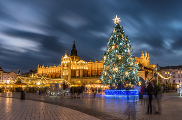 Fototapeta Krakow, Poland, Main Market square and Cloth Hall in the winter season, during Christmas fairs decorated with Christmas tree. obraz