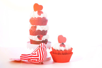 Triple layer red and white Valentine's Day cupcake with heart and love bug decorations and love bird ornament, and lens flare.