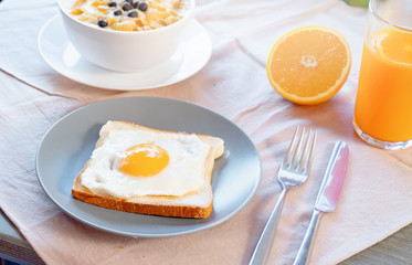 Toast with fried egg, orange juice and cornflakes with milk and berries. Healthy breakfast.