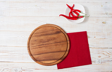 empty pizza desk,chili peper and red napkin on wooden table top view