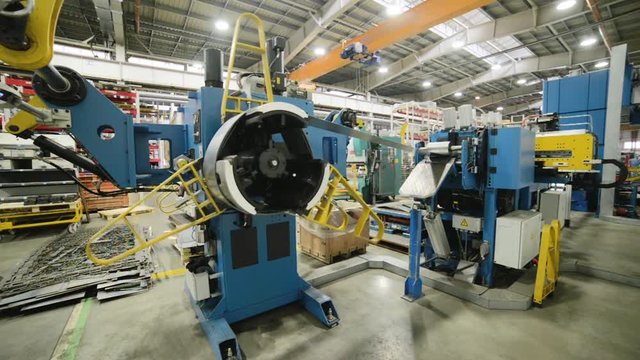 Cold rolled steel coil on decoiler of machine in metalwork manufacturing.