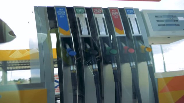 Filling station with a fuel pump seen through the window of a car