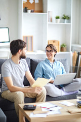 Obraz premium Young husband and wife consulting about family budget and discussing opportunity of travel