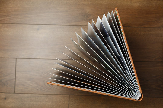 open photo book pages. brown photo book with  leather cover on wooden background. Photo album with a open turns and copyy space for your text