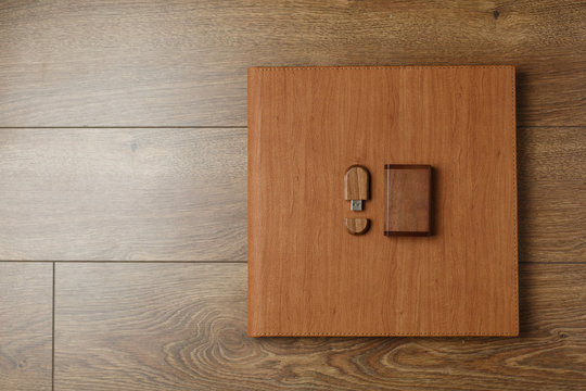 photobook in a leather cover with a photo print
photo album and flash drive on a wooden background