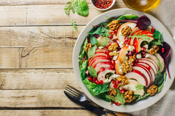 Healthy multi greens salad plate with apple, walnut, pomegranate, cheese