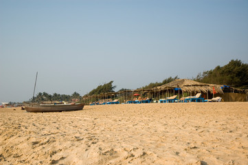 Fototapeta na wymiar Fishing boat standing on the beach in Goa on a hot Sunny day.