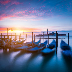 Moving gondola boats in harbor. Early morning with sunrise in Venice, Italy, Europe.