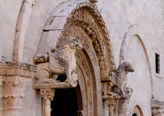 una coppia di grifoni sostiene l'arco del portale maggiore della Cattedrale di Ruvo di Puglia;