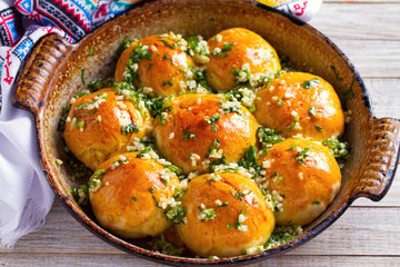 Buns Pampushky - Ukrainian garlic bread. Bread rolls with garlic and parsley in baking dish