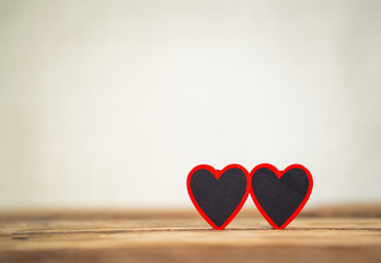 Conceptual image of couple of hearts together on vintage wooden table for love and Valentines day