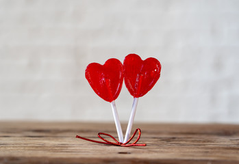 Two red heart shaped lollipops as metaphor of love, togetherness and Valentines day concept