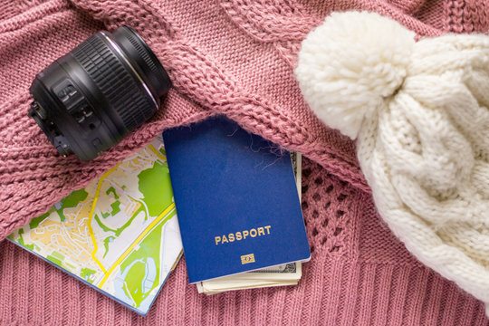 Concept of winter travelling with international biometric passport and map for navigation. Economical trips and sightseeing. Photography lens accessories for journeys.
