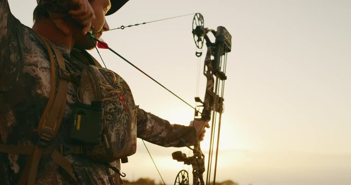 Orbit shot of experienced bowhunter poised to shoot his arrow