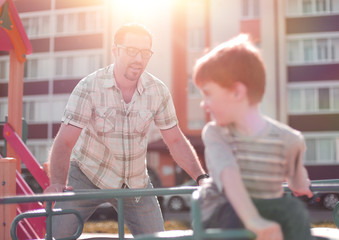 happy father playing with little boy on the Playground