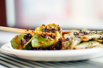 Chopsticks holding a vegetarian Chinese dumpling