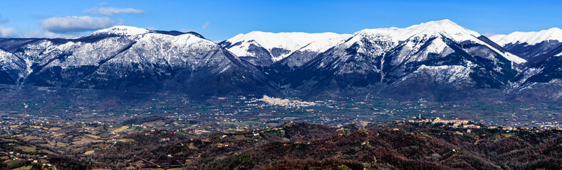 scenic winter landscape of the Italian Comino valley under the Marsicani mountain range