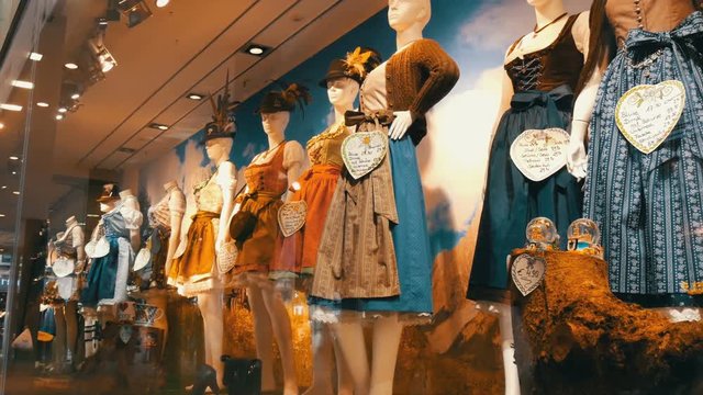 Beautiful various women's national Bavarian costumes dirndl on shop window