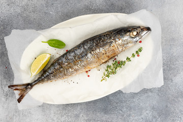 Baked mackerel fish on gray concrete background, top view