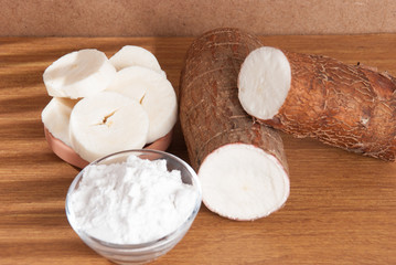 Raw cassava tuber on wooden background - Manihot esculenta